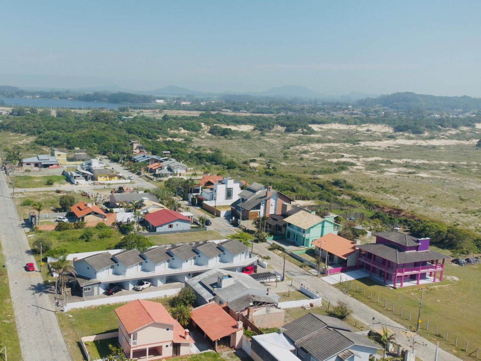 Foto aérea destacando a localização privilegiada do imóvel de frente para a reserva ambiental do Morro dos Conventos em Santa Catarina.